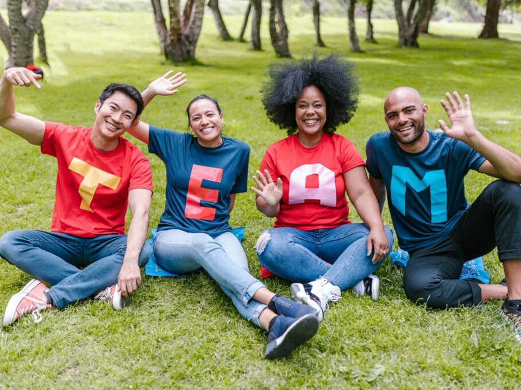 quatre jeunes assis sur l'herbe en souriant